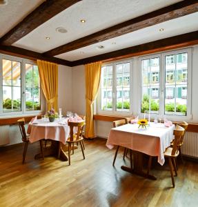 AarwangenGasthof zum Wilden Mann的一间设有两张桌子和窗户的用餐室
