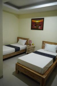 BanjarangkanUmah Desa的一间设有两张床的客房,墙上挂着一张照片