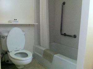 West Lebanon日落汽车旅馆的浴室设有卫生间和带淋浴帘的浴缸。