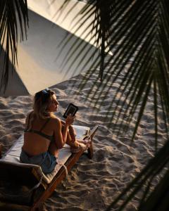 尼拉瓦利兰卡豆蔻的坐在沙滩椅上读书的女人