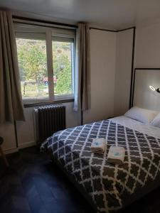 莫达讷hotel de la gare的一间卧室配有一张床,上面有两条毛巾