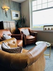 锡豪西斯Beach House Hotel的带沙发和椅子的客厅以及窗户。