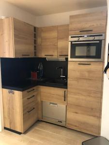 圣西普里安Golf ground floor 2 bedrooms Apartment Saint Cyprien的厨房配有木制橱柜和炉灶烤箱。