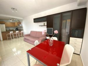 厄尔梅达诺Apartamentos Medano - La Ladera的客厅配有红色桌子和粉红色的沙发