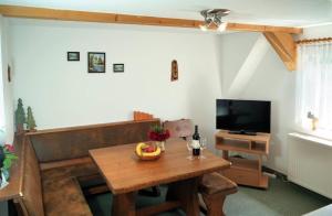 NeuhermsdorfKammbaude Neuhermsdorf的客厅配有木桌和电视。