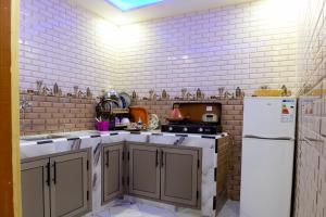 达赫拉aDAM的厨房设有白色砖墙和白色冰箱。