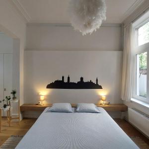 根特Bennestay的卧室配有一张白色大床和两盏灯。