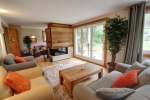 夏蒙尼-勃朗峰Chalet Clara的带沙发、桌子和壁炉的客厅