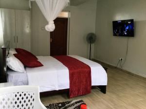 基苏木Milimani Comfort的一间卧室配有一张带红白毯子的床