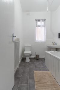 利物浦Modern 4bedroom Spacious Family Home的浴室配有卫生间、浴缸和水槽。