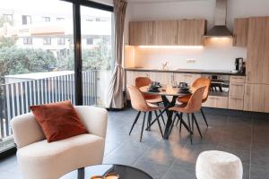 扎芬特姆K&Y suites 2 ,500m to Brussels airport!的厨房以及带桌椅的起居室。