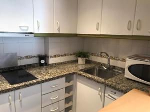 马拉加Appartement à MALAGA的厨房配有白色橱柜和水槽