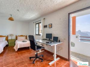 阿尔特纳拉Living Artenara - NATURE Adults Only的客房设有一张书桌、一台电脑和一张床