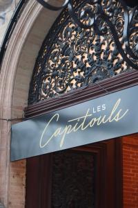 图卢兹Hotel Les Capitouls Toulouse Centre - Handwritten Collection的建筑物一侧的标志