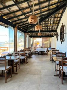 莫罗圣保罗波萨达莫雷纳酒店的餐厅设有木桌、长凳和窗户。