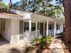 杰基尔岛Jekyll Island House/ Kellys On The Coast /King bed的门廊上带白色椅子的房子