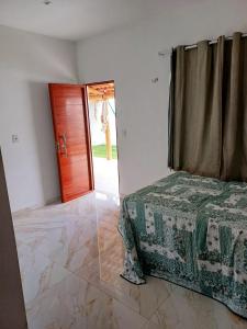圣若泽-迪里巴马尔Cantinho da Praia do Meio的一间卧室配有一张床和一扇木门