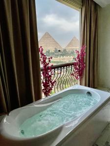 开罗Unique Pyramids View INN的金字塔窗前的浴缸