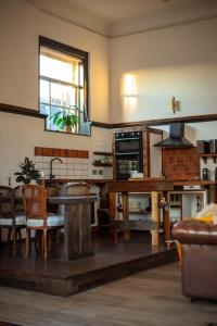 阿洛厄Spacious & Light Studio Loft的一间带木桌的客厅和一间厨房