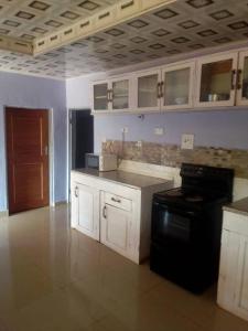 奇帕塔Faigib Guest House的厨房配有白色橱柜和黑炉。