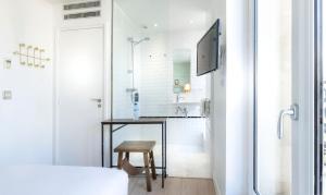 巴黎Hôtel Emile Le Marais的带淋浴和桌子的白色浴室