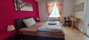 DullikenEdel Apartments Dulliken的一间卧室配有一张粉红色墙壁的床