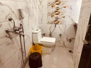 瑞诗凯诗The For You Hotel & Restaurant的浴室设有卫生间和黄色垃圾桶