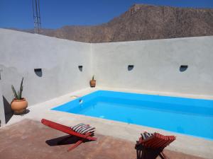 卡法亚特cabaña merlot的白色墙壁上的蓝色游泳池,配有两把椅子