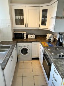 伦敦JB Stays Tooting的厨房配有白色橱柜和洗衣机。