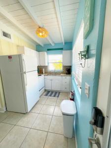 卡纳维拉尔角Cozy Canaveral Cottages的厨房配有白色冰箱和蓝色的墙壁