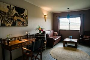 多多马Domiya Estate Ltd的客厅配有沙发、桌子和书桌