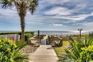 默特尔比奇Oceanview,Modern, Luxury, Carolinian Resort的一条通往海滩的木道,一条棕榈树