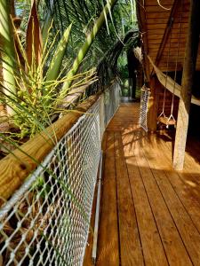 圣罗斯PURA VIDA Lodge Cabane perchée的木甲板上设有吊床和植物