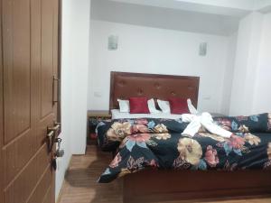 拉瓦格拉Sikkimese Inn的一间卧室配有一张带鲜花床罩的床