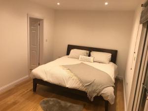法纳姆Redhill Lodge的一间卧室配有带白色床单和枕头的床。