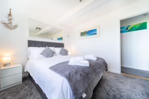 纽基Newquay Sunset & Sea View Apartment in Town Centre的卧室配有一张白色的大床和床头柜。
