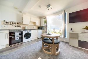 纽基Newquay Sunset & Sea View Apartment in Town Centre的厨房配有桌子、水槽和炉灶。