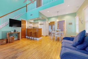 基韦斯特Baya House的一间带蓝色沙发的客厅和一间厨房