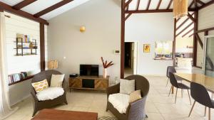 莱昂斯-达赫雷Villa de charme avec piscine et magnifique vue mer的客厅配有桌椅和电视。