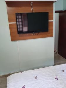 弗洛里亚诺波利斯POUSADA JURERE的客房设有一张壁挂式平面电视的床。