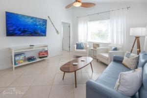 皮尔斯堡Hutchinson Island Beach House - Sleeps 32 - 8 BD的客厅配有蓝色的沙发和桌子