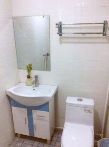华阴华山戈辉宾馆的一间带卫生间、水槽和镜子的浴室