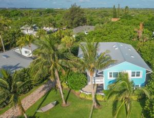 皮尔斯堡Hutchinson Island Beach House - Sleeps 32 - 8 BD的棕榈树蓝色房子的空中景色