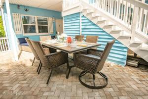 皮尔斯堡Hutchinson Island Beach House - Sleeps 32 - 8 BD的庭院里的餐桌和椅子