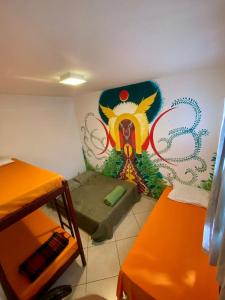 迪维诺波利斯HOSTEL Divinópolis的墙上挂着壁画的小房间