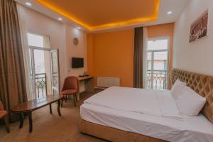 巴库Madinah Hotel的酒店客房设有一张床、一张书桌和窗户。