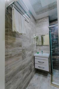 巴库Madinah Hotel的一间带玻璃淋浴和水槽的浴室