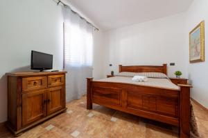 卡斯泰诺福奇伦托Residence Martino - Casa Vacanze的一间卧室配有一张床和一台平面电视