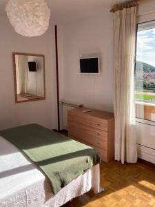 里瓦德塞利亚La Piragua的一间卧室配有一张床、一个梳妆台和一扇窗户。