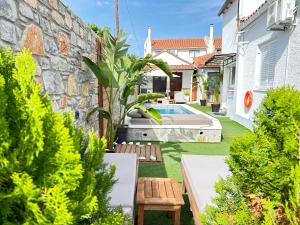 斯基亚索斯镇Del Sol Suites的一个带游泳池和房子的花园